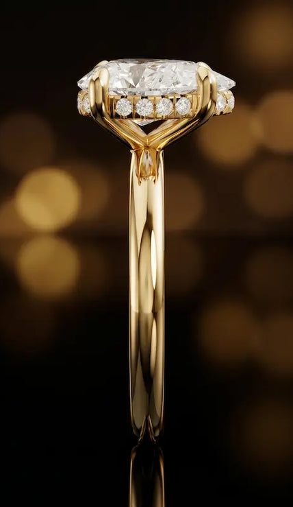 Side profile of 4-claw pear cut engagement ring with hidden halo in 18kt yellow gold