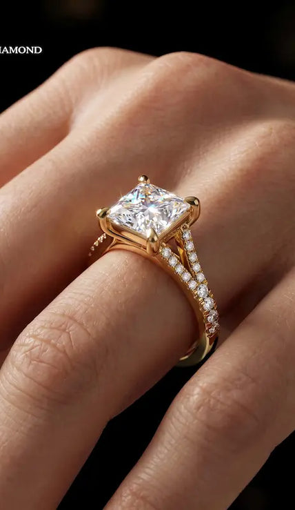 Princess cut split shank lab-grown diamond engagement ring worn on hand in 18kt yellow gold.