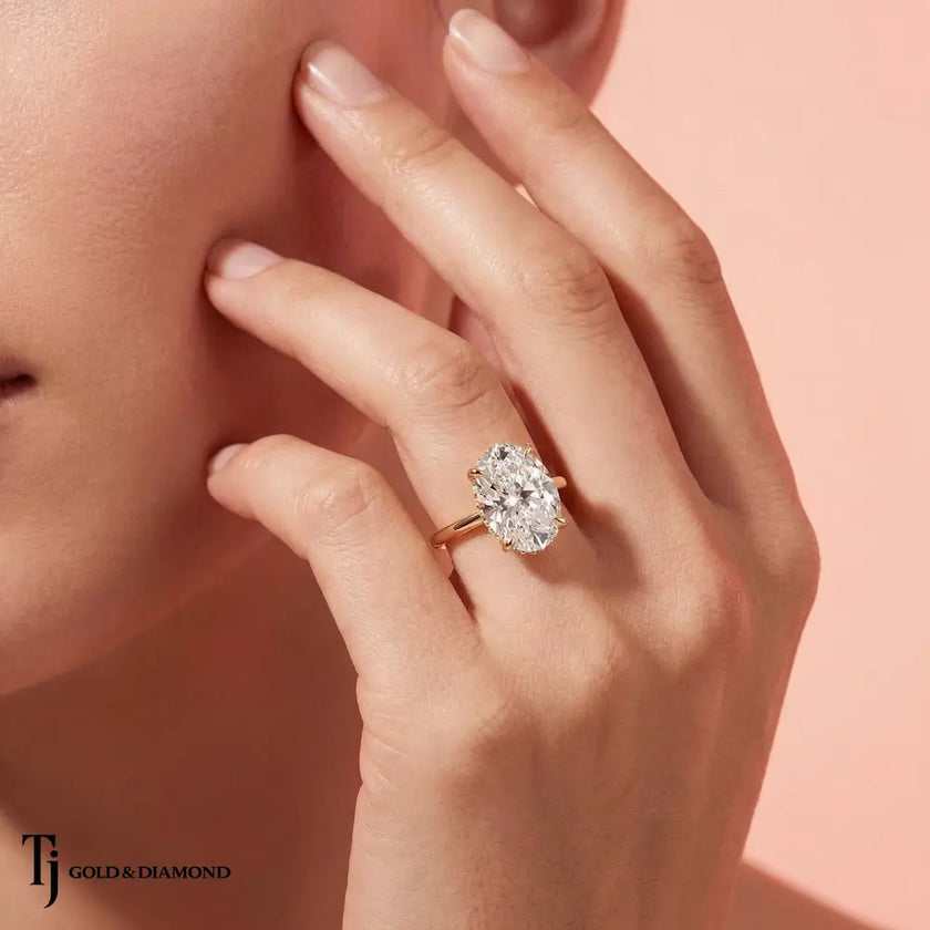 Model wearing a 4ct oval lab-grown diamond solitaire engagement ring in 18kt yellow gold.