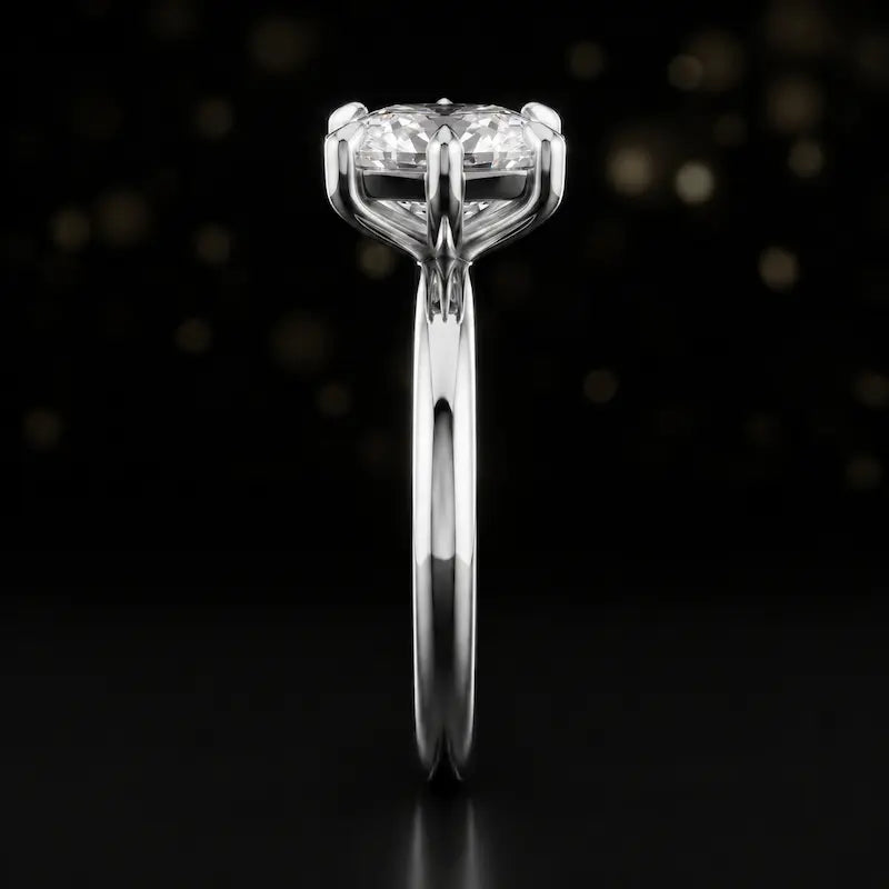 Side profile of a 1.5 carat cushion cut diamond solitaire engagement ring showing the cathedral setting and 18kt white gold band by TJ Diamond