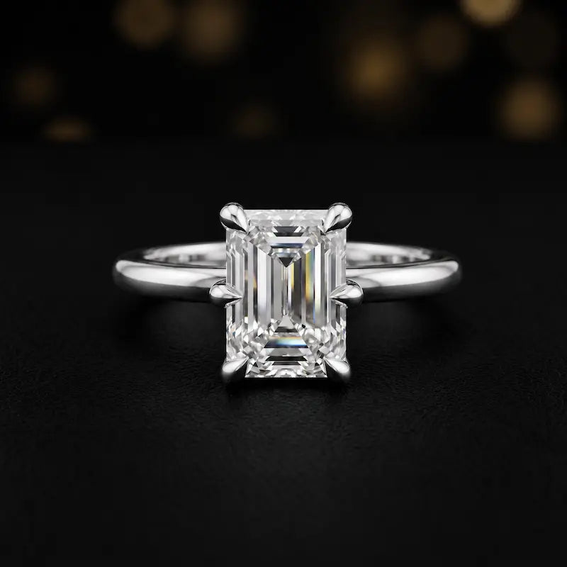 Front view of a 1.5 carat emerald cut diamond solitaire engagement ring in an 18kt white gold 6 claw setting by TJ Diamond
