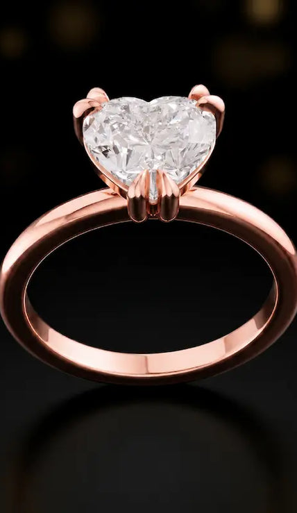Front view of a 1.5 carat heart cut diamond solitaire engagement ring in an 18kt rose gold 6 claw setting by TJ Diamond