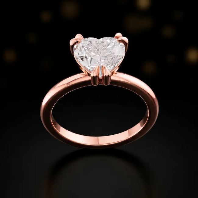 Front view of a 1.5 carat heart cut diamond solitaire engagement ring in an 18kt rose gold 6 claw setting by TJ Diamond