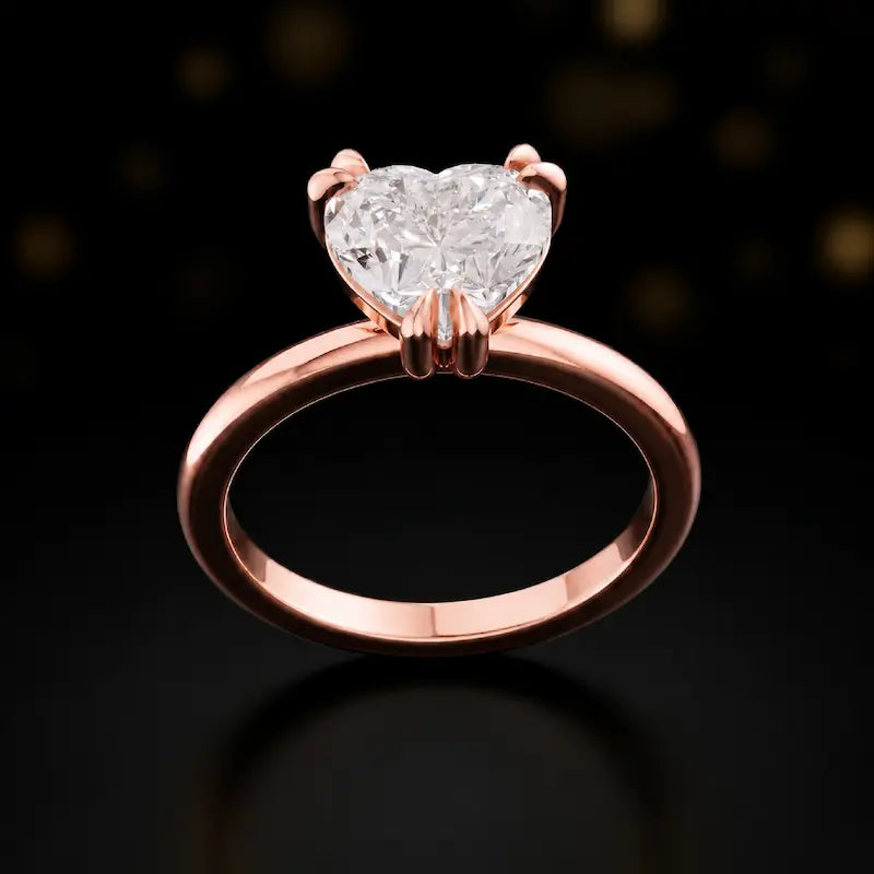 Front view of a 1.5 carat heart cut diamond solitaire engagement ring in an 18kt rose gold 6 claw setting by TJ Diamond