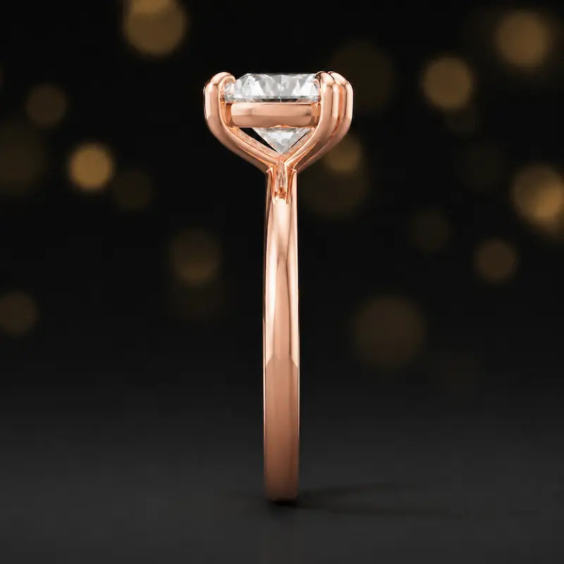 Side profile of a 1.5 carat heart cut diamond solitaire engagement ring showing the cathedral setting and 18kt rose gold band by TJ Diamond