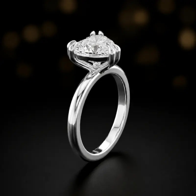 Front-on view of a 1.5 carat heart cut diamond solitaire engagement ring showing the full 18kt white gold band and 6 claw cathedral setting by TJ Diamond