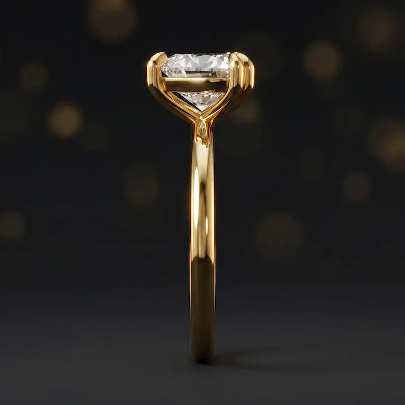 Side profile of a 1.5 carat heart cut diamond solitaire engagement ring showing the cathedral setting and 18kt yellow gold band by TJ Diamond