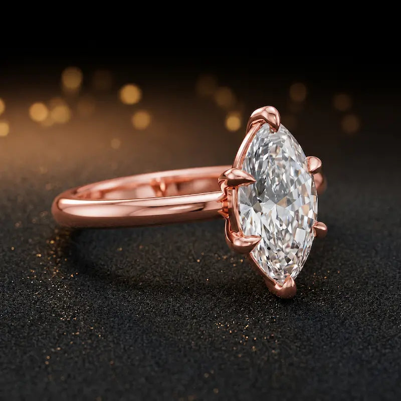 Front-on view of a 1.5 carat marquise cut diamond solitaire engagement ring showing the full 18kt rose gold band and 6 claw cathedral setting by TJ Diamond