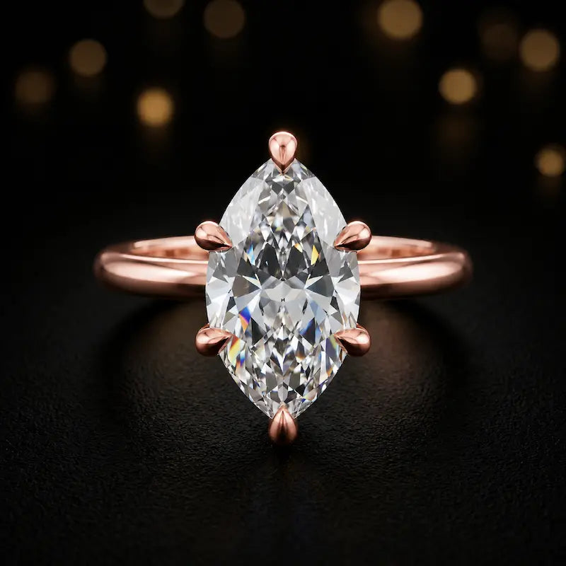 Front view of a 1.5 carat marquise cut diamond solitaire engagement ring in an 18kt rose gold 6 claw setting by TJ Diamond