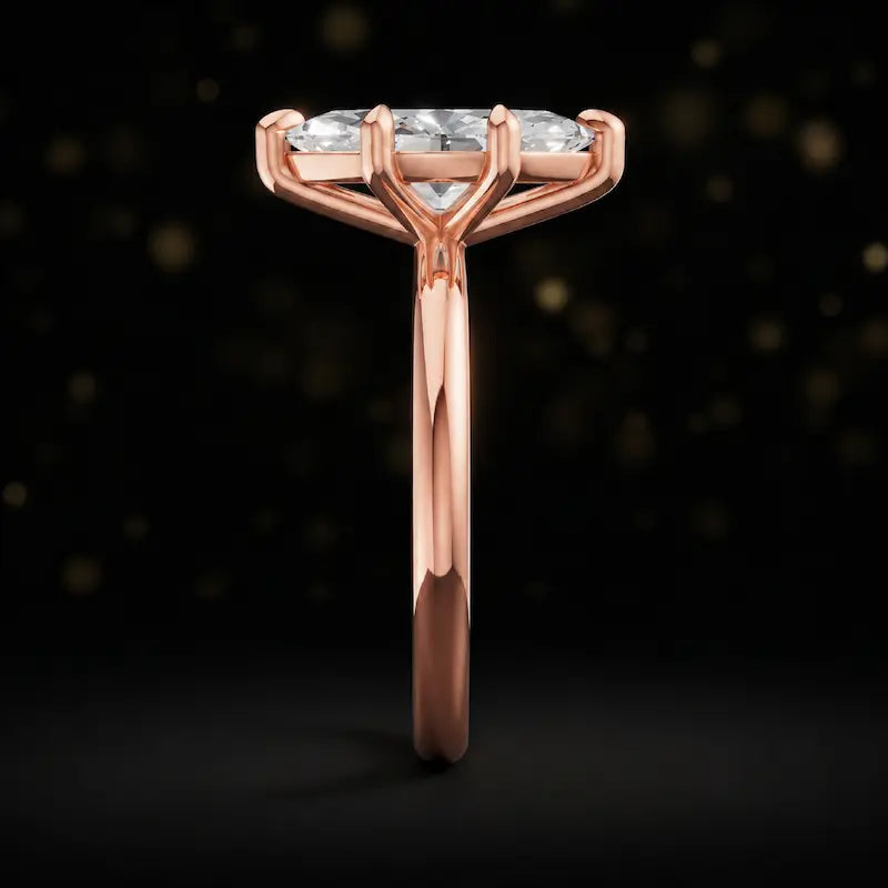 Side profile of a 1.5 carat marquise cut diamond solitaire engagement ring showing the cathedral setting and 18kt rose gold band by TJ Diamond