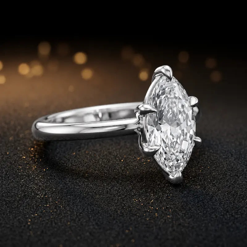 Front-on view of a 1.5 carat marquise cut diamond solitaire engagement ring showing the full 18kt white gold band and 6 claw cathedral setting by TJ Diamond
