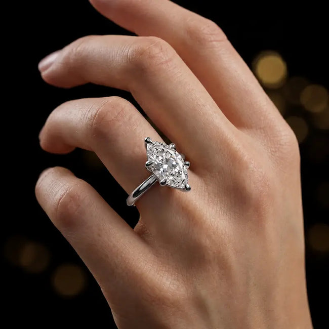 1.5 carat marquise cut diamond solitaire engagement ring in an 18kt white gold 6 claw setting worn on a hand, by TJ Diamond