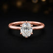 Front view of a 1.5 carat oval cut diamond solitaire engagement ring in an 18kt rose gold 6 claw setting by TJ Diamond