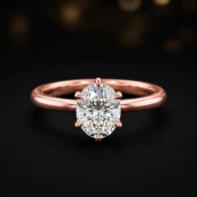 Front view of a 1.5 carat oval cut diamond solitaire engagement ring in an 18kt rose gold 6 claw setting by TJ Diamond