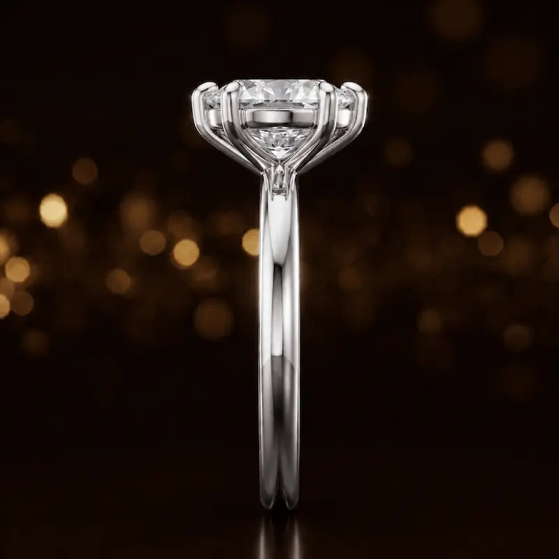 Side profile of a 1.5 carat oval cut diamond solitaire engagement ring showing the cathedral setting and 18kt white gold band by TJ Diamond