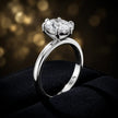 Front-on view of a 1.5 carat oval cut diamond solitaire engagement ring showing the full 18kt white gold band and 6 claw cathedral setting by TJ Diamond