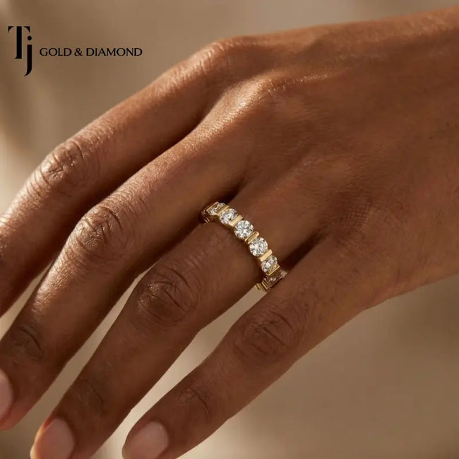 Full eternity diamond wedding band in 18kt yellow gold worn on hand with round brilliant lab-grown diamonds in a modern bar setting.