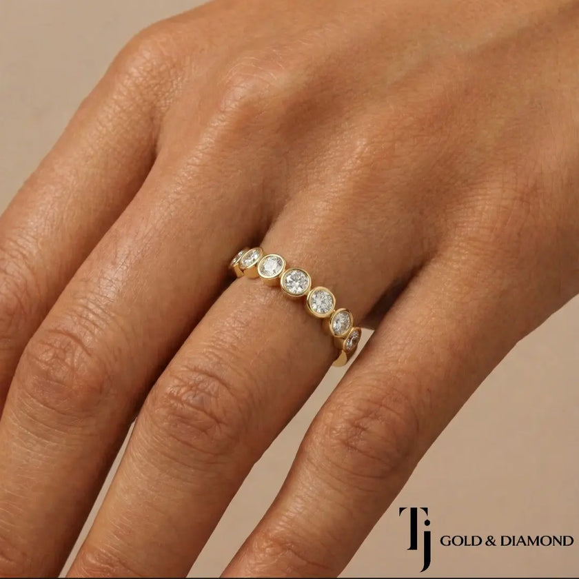 Bezel Setting Half Eternity diamond wedding band in 18kt yellow gold, worn on hand