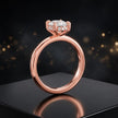 Front view of 4-claw cushion cut engagement ring with hidden halo in 18kt rose gold