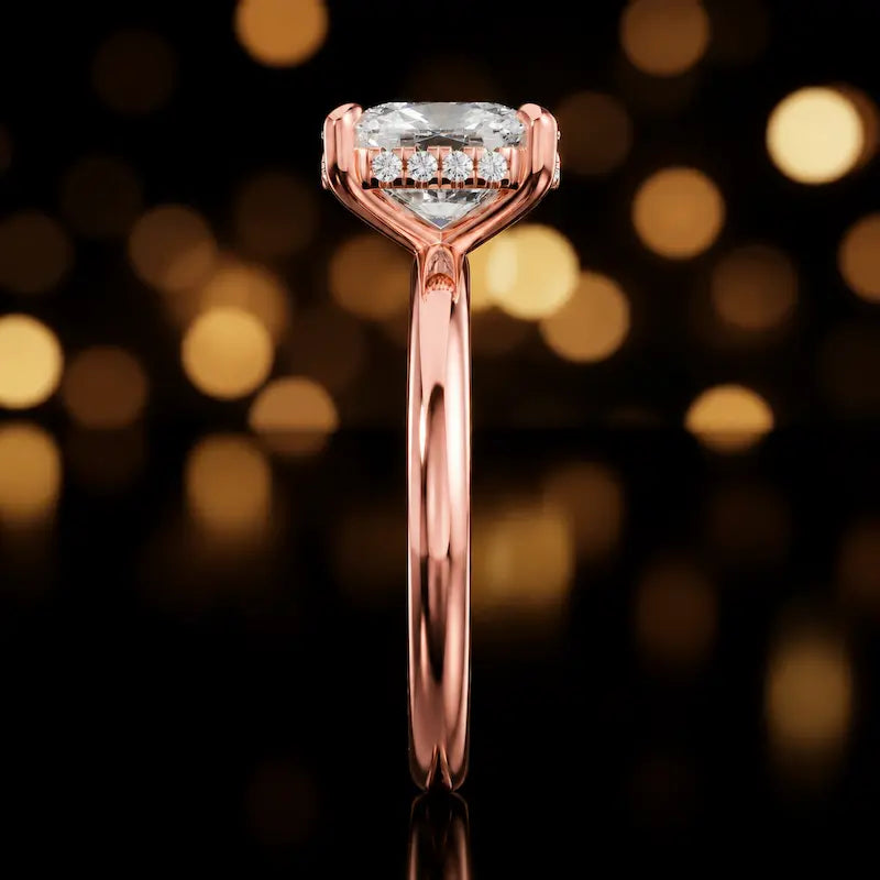Side profile of 4-claw cushion cut engagement ring with hidden halo in 18kt rose gold