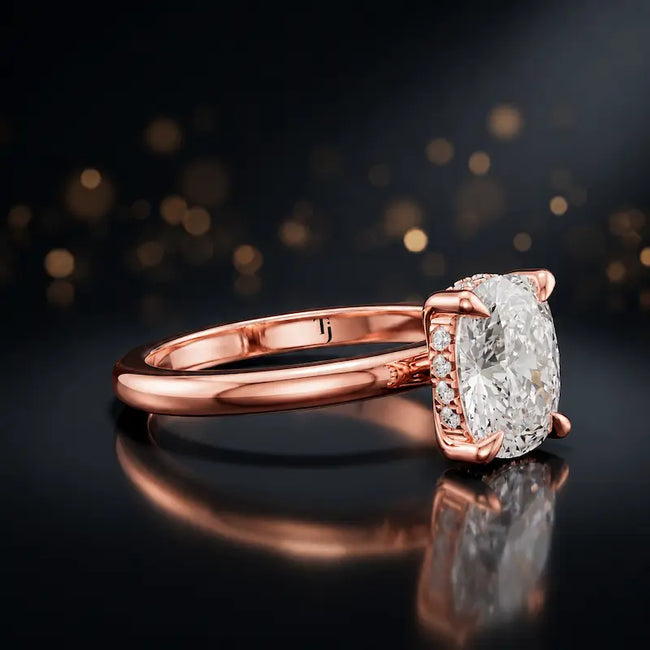 Angled view of 4-claw cushion cut engagement ring with hidden halo in 18kt rose gold