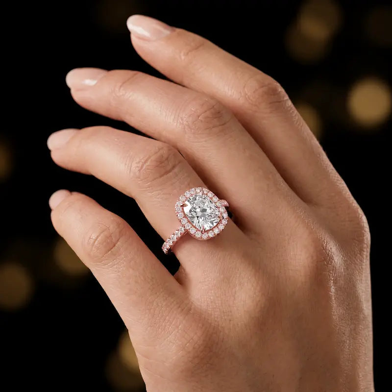 Cushion cut halo lab-grown diamond engagement ring worn on hand in 18kt rose gold.