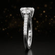 Side profile of a cushion cut three-stone diamond engagement ring in 18kt white gold showing the band elevation and diamond shoulders