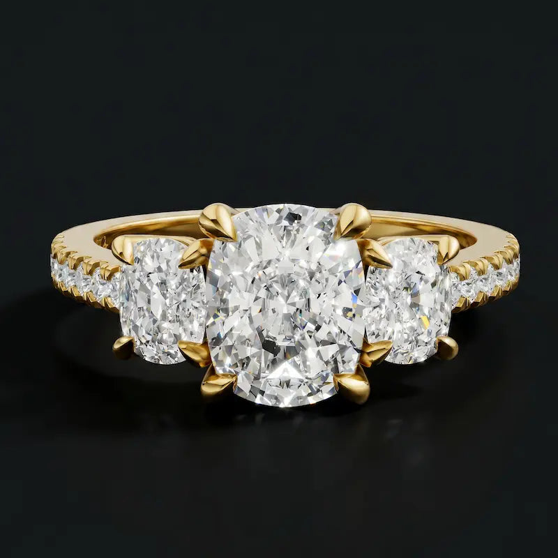 Front view of a cushion cut three-stone lab-grown diamond engagement ring in 18kt yellow gold with diamond shoulders