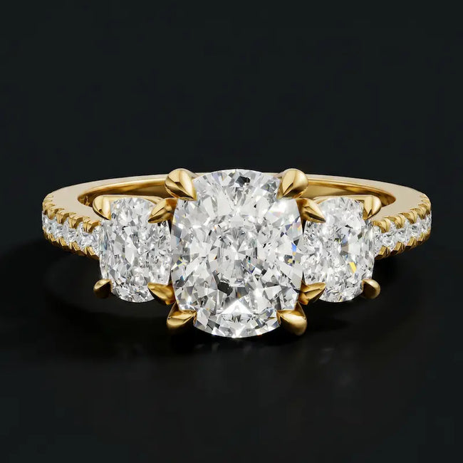 Front view of a cushion cut three-stone lab-grown diamond engagement ring in 18kt yellow gold with diamond shoulders