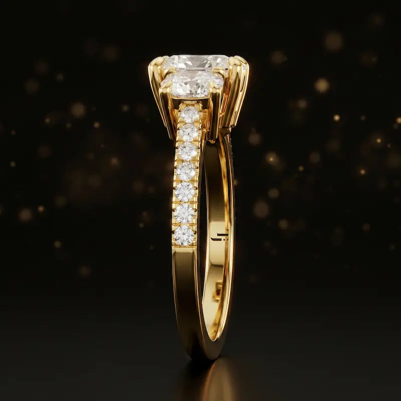 Side profile of a cushion cut three-stone lab-grown diamond engagement ring in 18kt yellow gold showing the diamond band