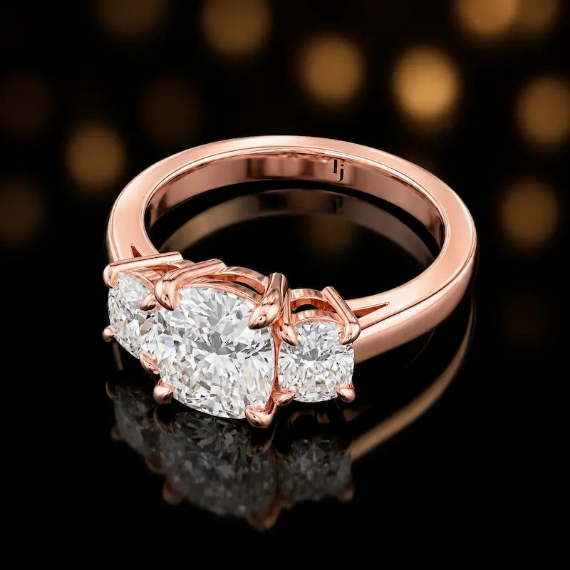 Angled view of a cushion cut lab-grown diamond trilogy engagement ring in 18kt rose gold.