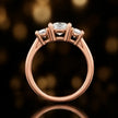 Side profile of a handcrafted cushion cut lab-grown diamond trilogy ring in 18kt rose gold showing the basket setting.