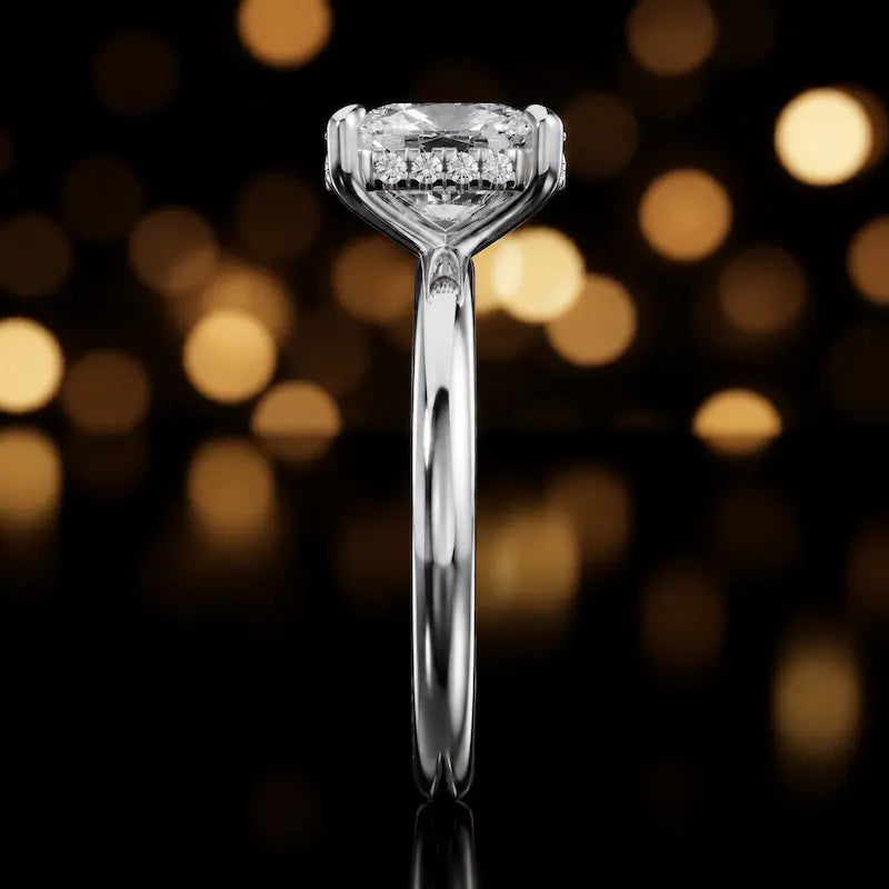 Side profile of 4-claw cushion cut engagement ring with hidden halo in 18kt white gold