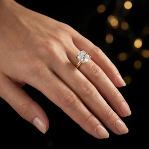 4-claw cushion cut engagement ring with hidden halo in 18kt yellow gold, worn on hand