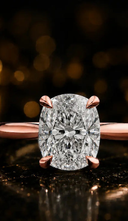 Front view of a 1.5 carat cushion cut diamond solitaire engagement ring in an 18kt rose gold 4 claw setting by TJ Diamond
