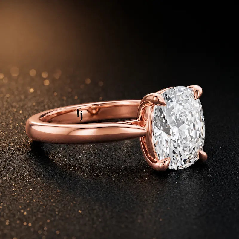 Angled side view of a 1.5 carat cushion cut diamond solitaire engagement ring in an 18kt rose gold 4 claw setting by TJ Diamond