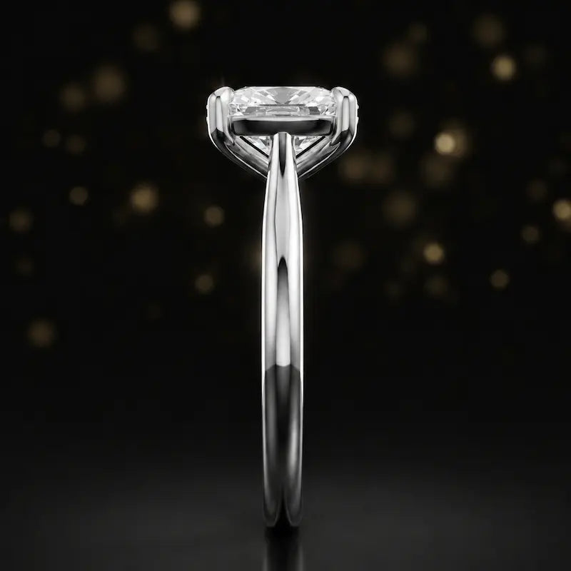 Side profile of a 1.5 carat cushion cut diamond solitaire engagement ring showing the cathedral setting and 18kt white gold band by TJ Diamond
