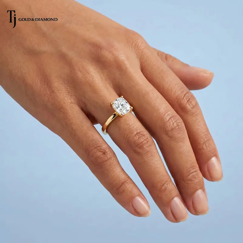 1.5 carat cushion cut lab-grown diamond solitaire engagement ring in 18kt yellow gold worn on hand