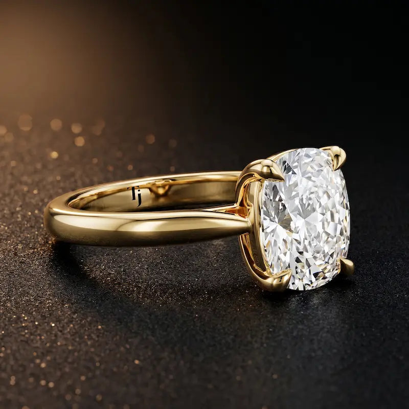 Angled side view of a 1.5 carat cushion cut diamond solitaire engagement ring in an 18kt yellow gold 4 claw setting by TJ Diamond