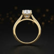 Front-on view of a 1.5 carat cushion cut diamond solitaire engagement ring showing the full 18kt yellow gold band and 4 claw cathedral setting by TJ Diamond