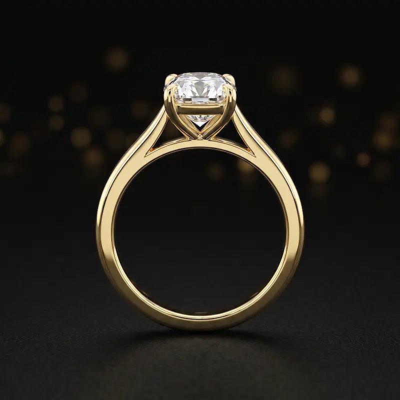 Front-on view of a 1.5 carat cushion cut diamond solitaire engagement ring showing the full 18kt yellow gold band and 4 claw cathedral setting by TJ Diamond