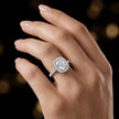 Cushion cut halo lab-grown diamond engagement ring worn on hand in 18kt white gold.