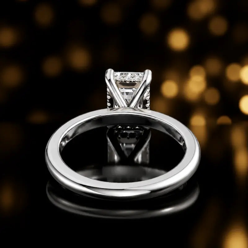 Back view of 4-claw emerald cut engagement ring with hidden halo in 18kt white gold