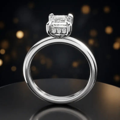 Front view of 4-claw emerald cut engagement ring with hidden halo in 18kt white gold