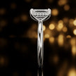 Side profile of 4-claw emerald cut engagement ring with hidden halo in 18kt white gold