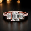 Front view of an emerald cut three-stone lab-grown diamond engagement ring in 18kt rose gold with diamond shoulders