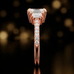 Side profile of an emerald cut three-stone lab-grown diamond engagement ring in 18kt rose gold showing the diamond band