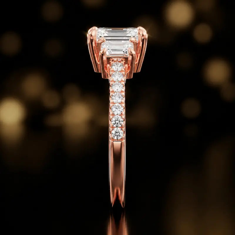 Side profile of an emerald cut three-stone lab-grown diamond engagement ring in 18kt rose gold showing the diamond band