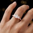 Emerald cut three-stone lab-grown diamond engagement ring in 18kt rose gold with diamond shoulders worn on hand