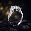 Angled view of an emerald cut three-stone lab-grown diamond engagement ring in 18kt white gold with diamond shoulders